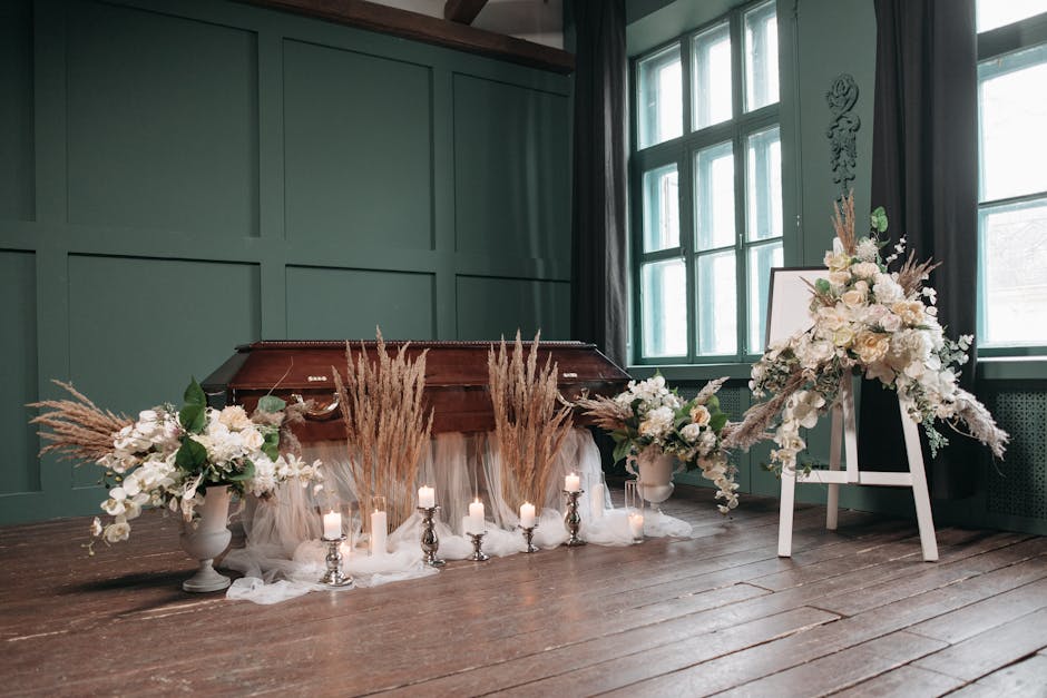 A floral arrangement featuring a large, white and cream-colored bouquet placed on an easel, accompanied by two matching vases filled with white roses, lilies, and other delicate blooms, complemented b